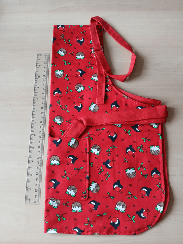 Childs Kitchen Play Apron Pudding Patterned Cotton Fabric with Front pocket and Red lining, waist ties and adjustable neck ties (1)