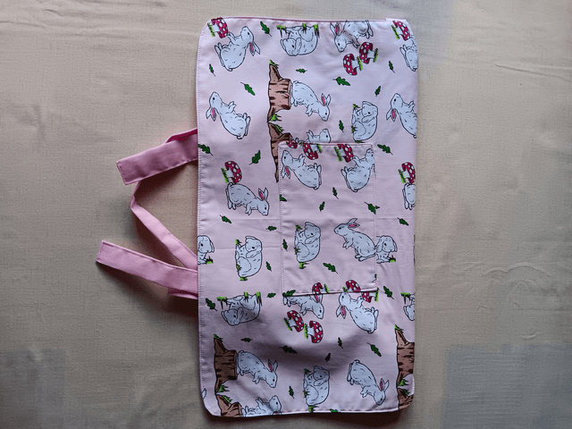 Childs Kitchen Play Apron Pink Bunnies Patterned Cotton Fabric with Front pocket and pink lining, waist ties and adjustable neck ties 