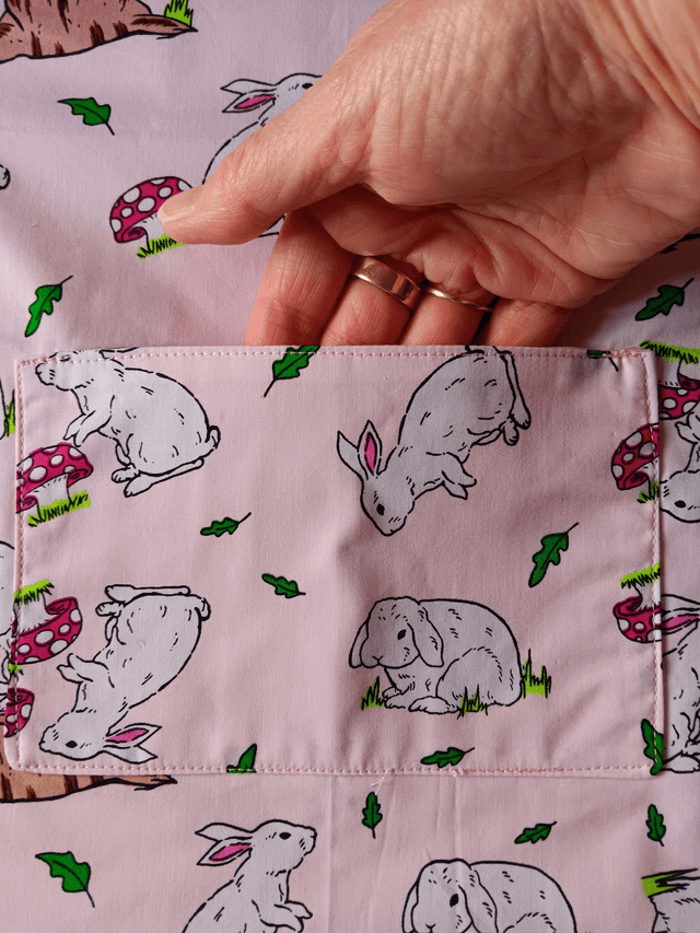 Childs Kitchen Play Apron Pink Bunnies Patterned Cotton Fabric with Front pocket and pink lining, waist ties and adjustable neck ties 