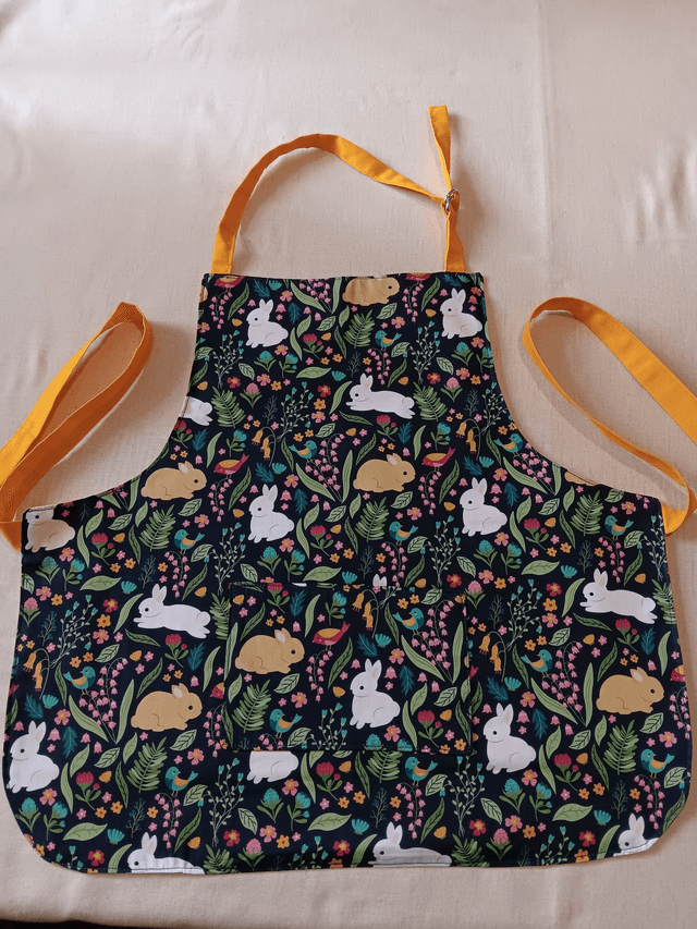 Childs Kitchen/Play Apron  Bunnies Patterned Navy Cotton Fabric with Lined Front pocket and yellow lining, waist ties and adjustable neck tie 