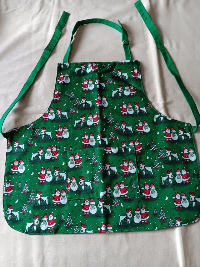 Childs Kitchen Play Apron Green Seasonal Print Cotton Fabric with Front pocket and Green lining, waist ties and adjustable neck ties 